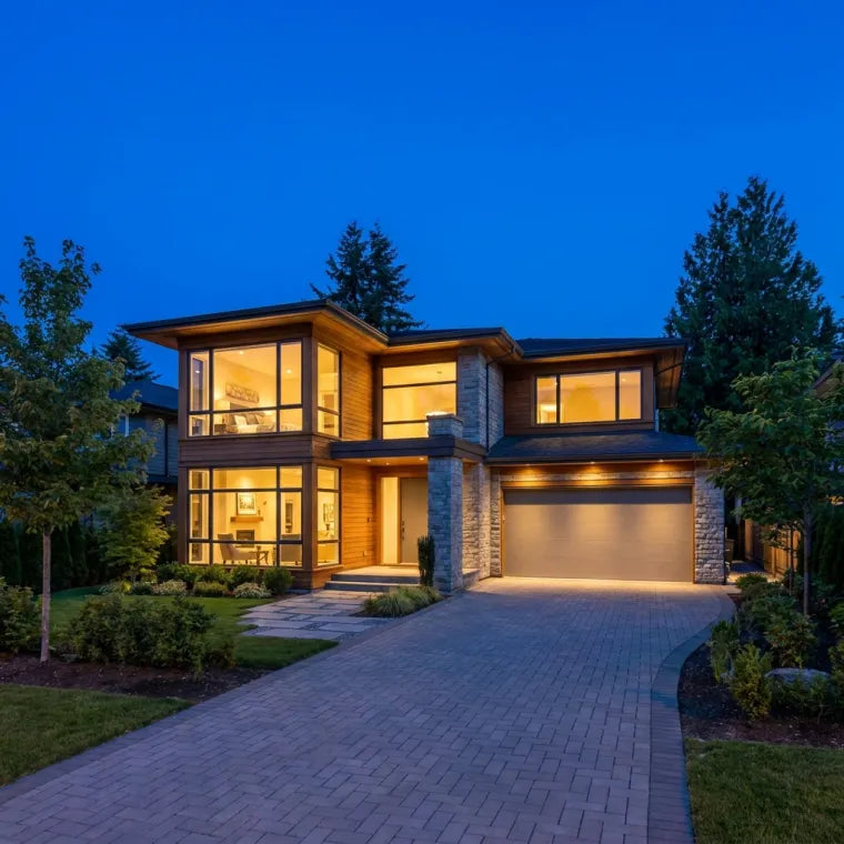 Modern home at dusk with warm interior lights