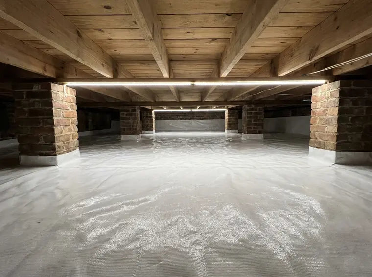 Encapsulated crawl space with white vapor barrier between brick piers